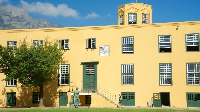 Yellow Castle building with sundial and statue